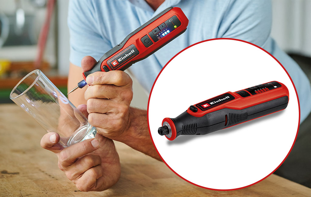 A man engraves a drinking glass with a red, cordless engraving tool from Einhell.