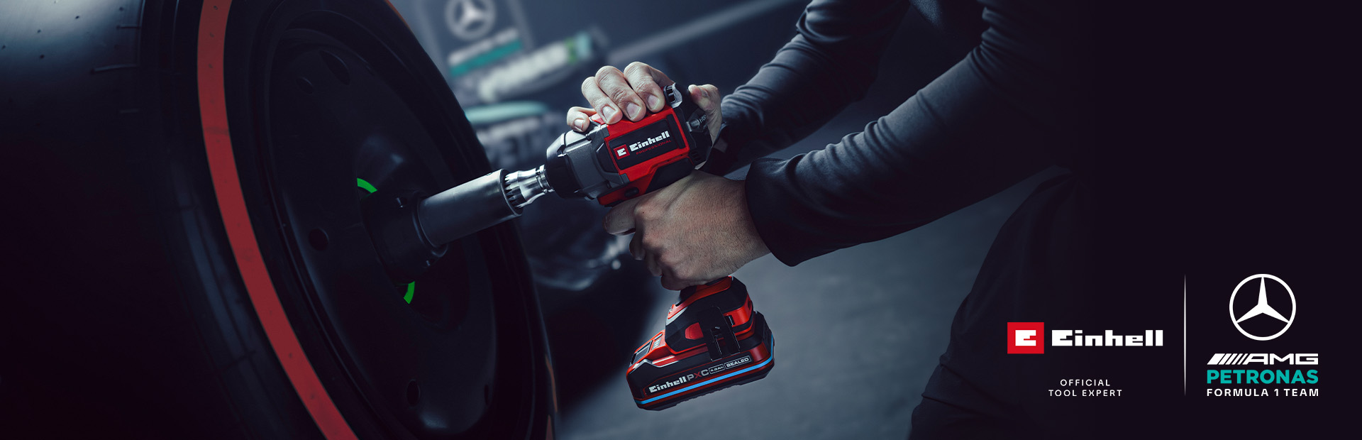 Einhell cordless impact wrench in use on a car wheel, with Mercedes-AMG Petronas Formula One Team branding and partnership logo