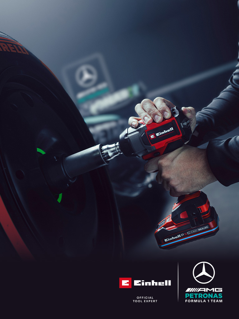 Einhell cordless impact wrench in use on a car wheel, with Mercedes-AMG Petronas Formula One Team branding and partnership logo