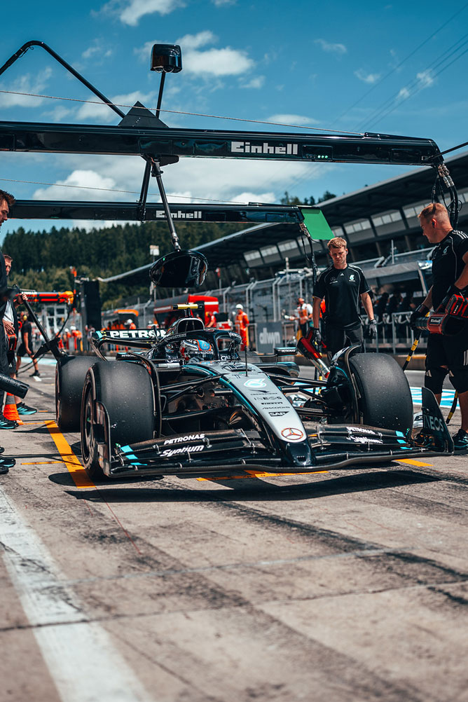 Mercedes-AMG Formula 1 dirkalnik je na pitlaneu, obdan s člani ekipe pod Einhell garažno strukturo.
