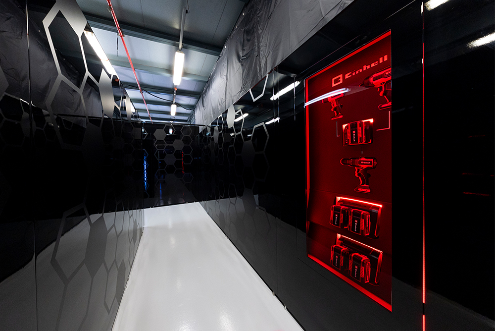 Hodnik v garaži Formule 1 v pit laneu z rdečo osvetlitvijo.