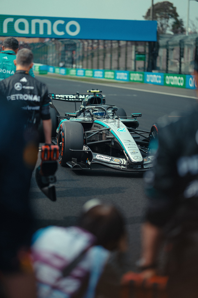 Mercedes F1 dirkalnik v boksih, obdan z ekipo