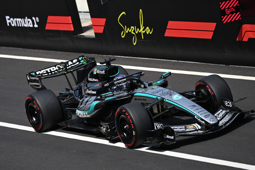 Mercedes F1 dirkalnik na stezi s sponzorskimi logotipi