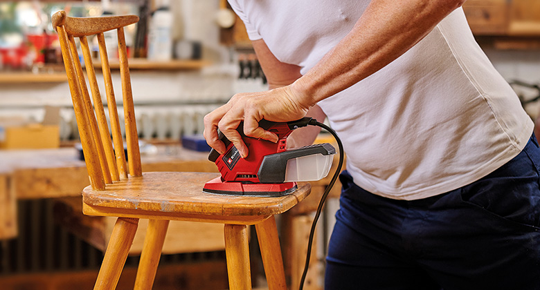 man using grinder for sanding wood