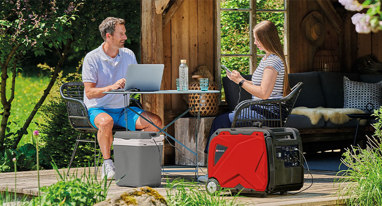 A woman and a man sat at a table next to a power generator